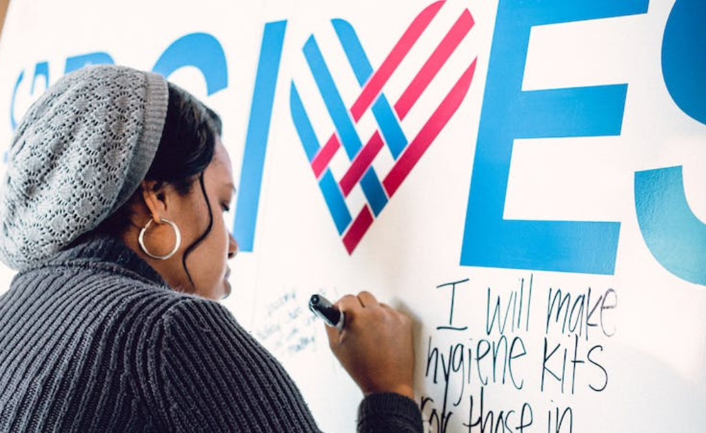 Woman writing on a wall with a Sharpie.