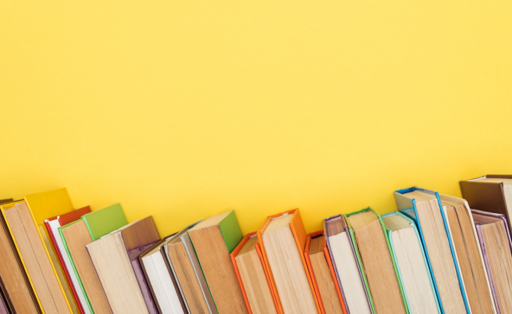 Books on a shelf with a yellow background.