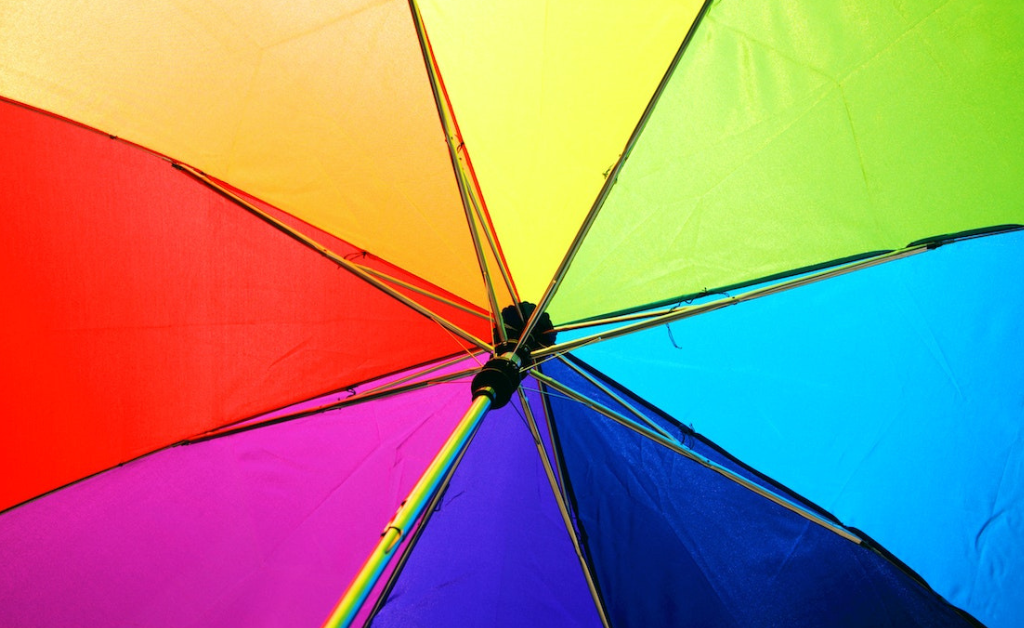 Looking up under a rainbow umbrella.