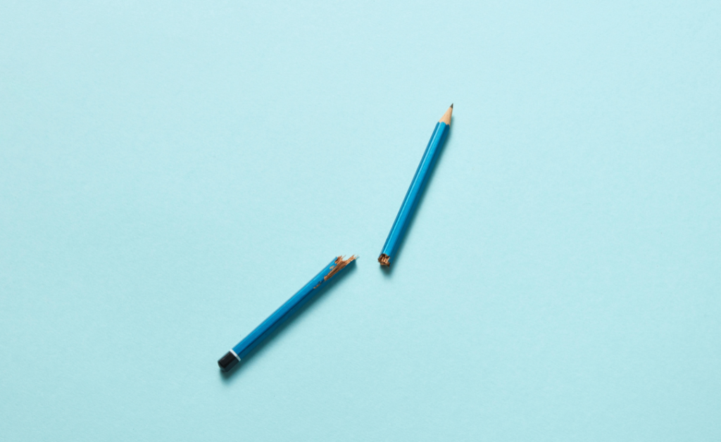Broken blue pencil on a blue background.